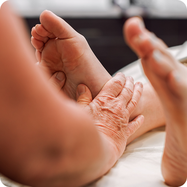 - The Renaissance Day Spa & Alternative Wellness, Fayetteville NC Close-up of an adult massaging a child's bare foot while the child lies down, reflecting the nurturing touch found in holistic alternative therapies. - The Renaissance Day Spa & Alternative Wellness, Fayetteville NC