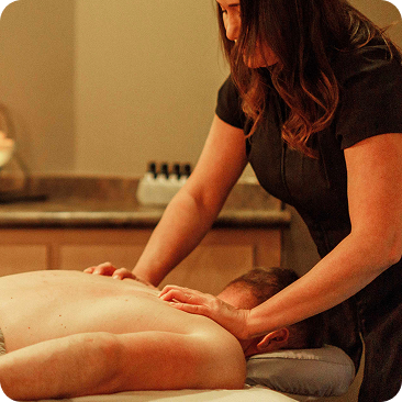 - The Renaissance Day Spa & Alternative Wellness, Fayetteville NC A massage therapist in a dark uniform gives a shoulder and neck massage to a person lying face down on a table in a spa setting, specializing in deep tissue massage therapy and holistic alternative therapies. - The Renaissance Day Spa & Alternative Wellness, Fayetteville NC