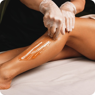 - The Renaissance Day Spa & Alternative Wellness, Fayetteville NC A person wearing gloves applies wax to another person's lower leg, preparing for a hair removal treatment as part of luxury day spa packages. - The Renaissance Day Spa & Alternative Wellness, Fayetteville NC