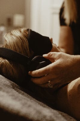 - The Renaissance Day Spa & Alternative Wellness, Fayetteville NC A person lying down with an eye mask and headphones while another hand adjusts the headphones. - The Renaissance Day Spa & Alternative Wellness, Fayetteville NC